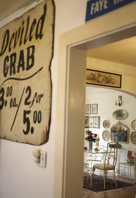  Hollie found this discarded wooden sign in a trash heap along Upper King Street, cleaned it up, and hung it on the wall in her kitchen. Nearby, the dining area is outfitted in old iron furniture.