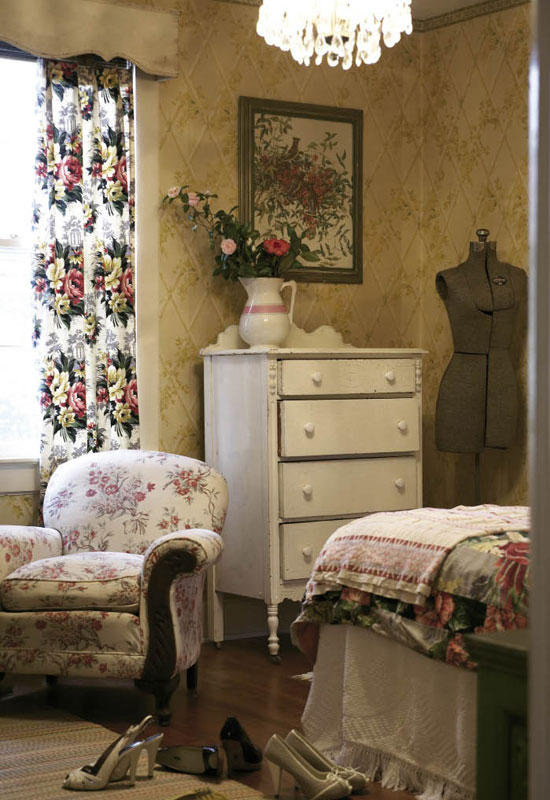  In the guest room, Hollie paired a “favorite dresser” she picked up for $30 with an old dress form and overstuffed armchair. As for the wallpaper, “The real estate agent said, ‘I’m sure you’ll tear it down as soon as you get a chance,’ and I said, ‘No way, that’s the best part!’” recalls Hollie.