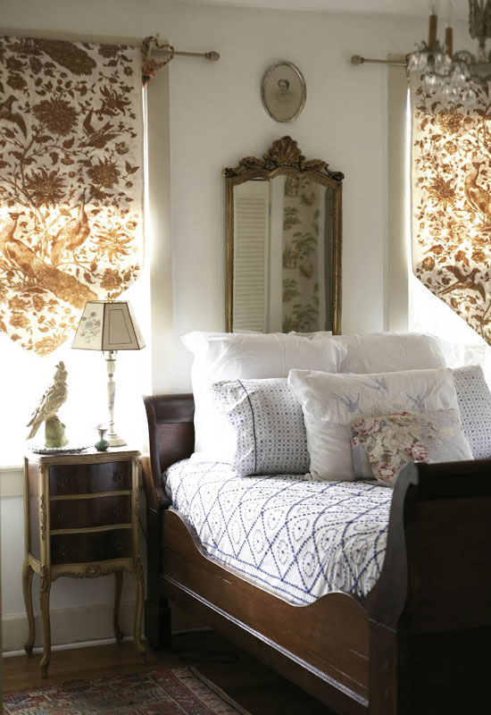 A chenille bedspread dresses the 19th-century, hand-carved sleigh bed Hollie received from her mother as a Christmas present. The shades feature a screen-printed peacock pattern.   